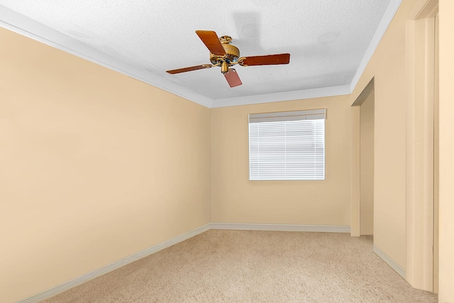 carpeted empty room with ceiling fan, ornamental molding, and a textured ceiling