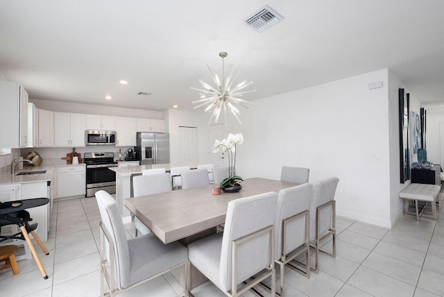 dining area with light tile patterned floors, sink, and a chandelier