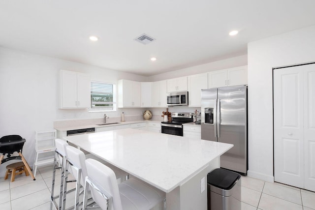 kitchen with a center island, white cabinetry, sink, and appliances with stainless steel finishes