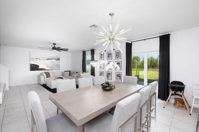 tiled dining room featuring ceiling fan with notable chandelier