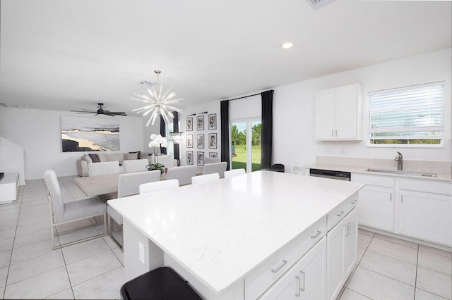 kitchen featuring white cabinets, a center island, sink, and a wealth of natural light