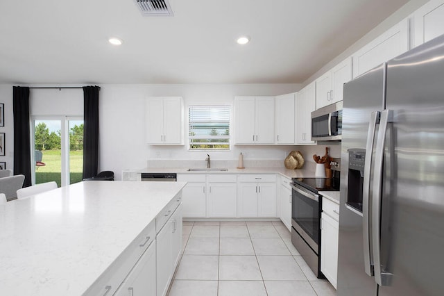 kitchen with plenty of natural light, sink, white cabinetry, and stainless steel appliances