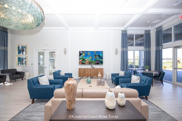 living room with beam ceiling, french doors, hardwood / wood-style floors, and coffered ceiling