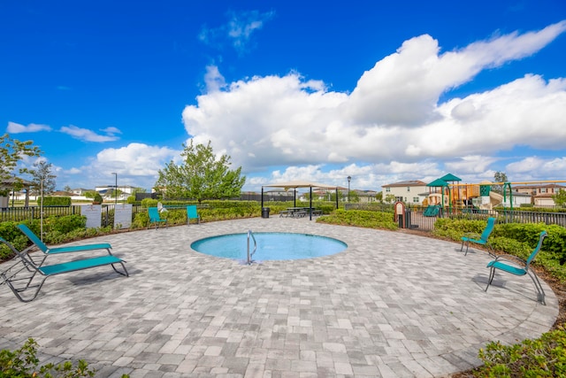 view of swimming pool featuring a patio and a playground