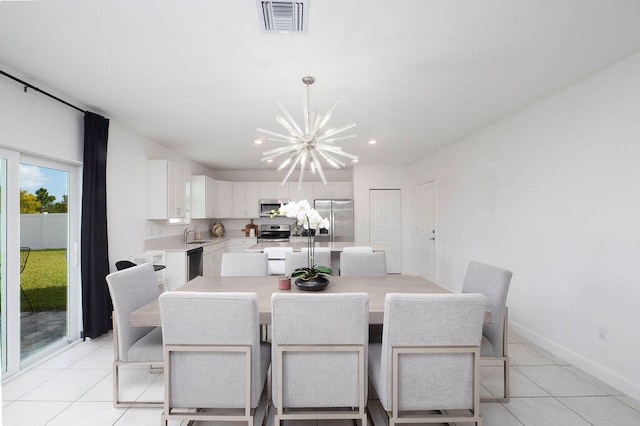 dining space featuring light tile patterned floors, sink, and an inviting chandelier