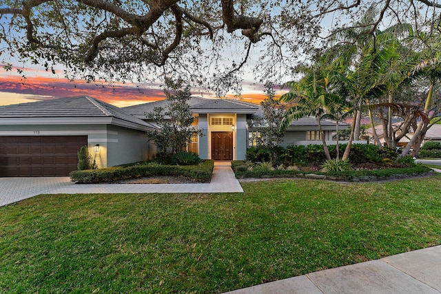 view of front of house with a garage and a lawn