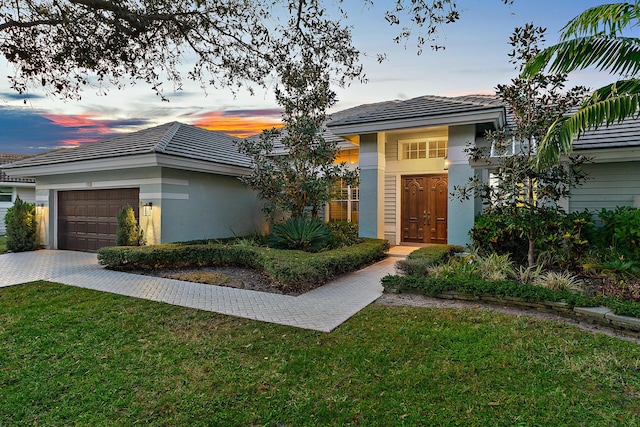 view of front of home with a lawn and a garage