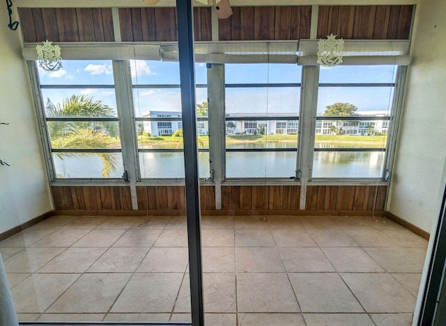 unfurnished sunroom featuring a water view and a notable chandelier