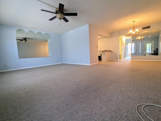 unfurnished living room with ceiling fan with notable chandelier and carpet flooring