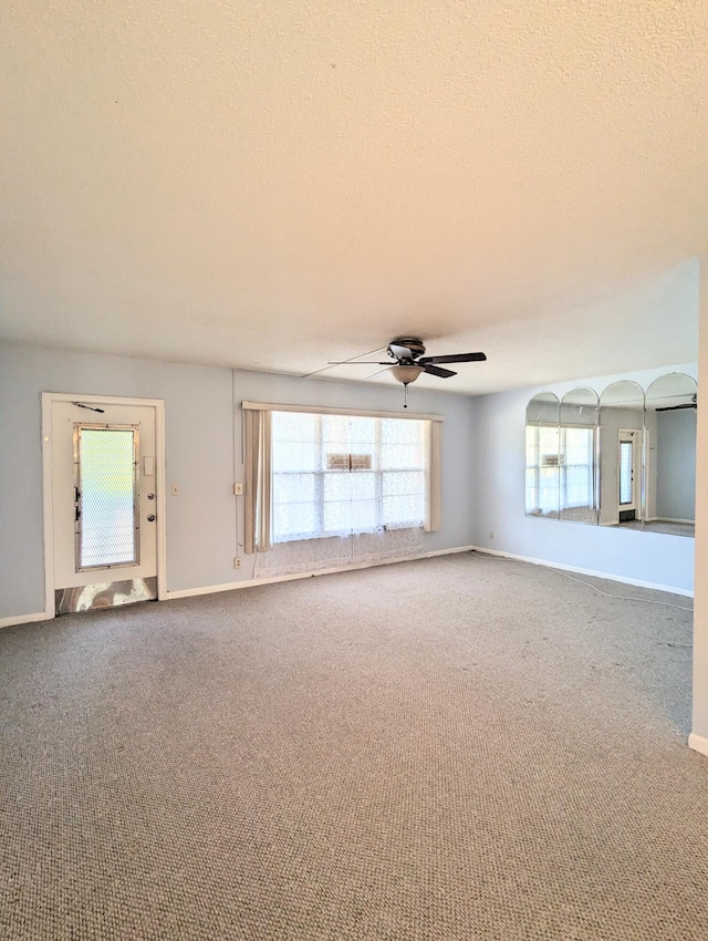 spare room featuring a textured ceiling, carpet flooring, and ceiling fan