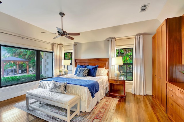 bedroom featuring ceiling fan, light hardwood / wood-style flooring, and lofted ceiling