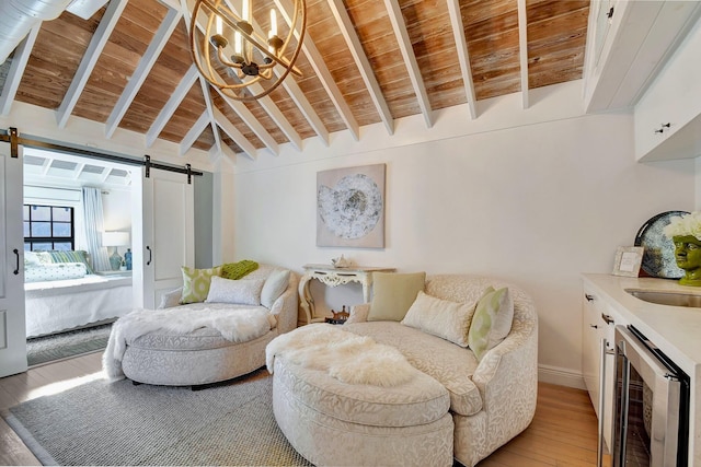 sitting room featuring wood ceiling, a barn door, light wood-type flooring, vaulted ceiling with beams, and wine cooler