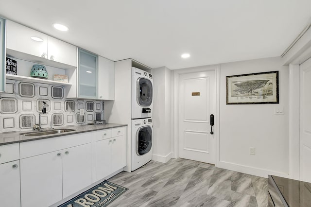 laundry area with sink and stacked washer / drying machine