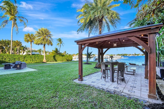 view of yard featuring a patio area, a gazebo, and a water view