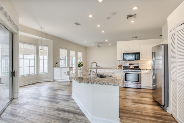 kitchen featuring sink, white cabinets, light hardwood / wood-style floors, and appliances with stainless steel finishes