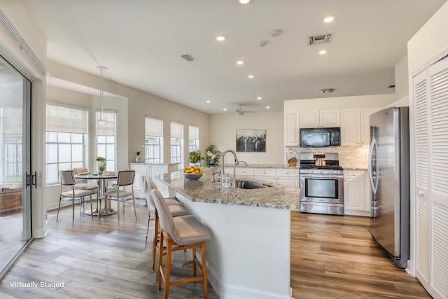 kitchen featuring white cabinets, light hardwood / wood-style floors, sink, and stainless steel appliances