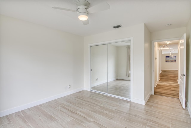 unfurnished bedroom with ceiling fan, a closet, and light hardwood / wood-style floors