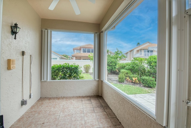 unfurnished sunroom with ceiling fan