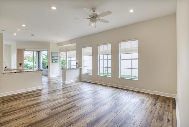 unfurnished living room with light wood-type flooring and ceiling fan