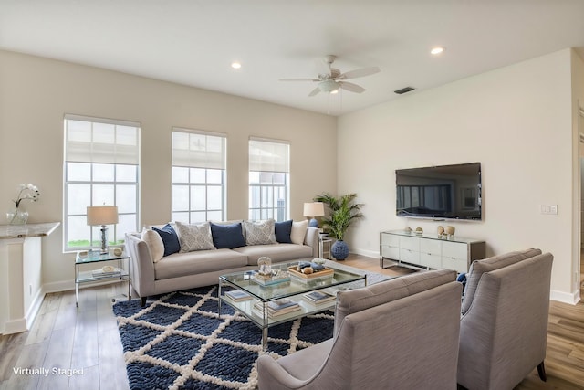 living room featuring wood-type flooring and ceiling fan