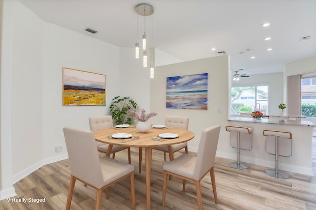 dining space with ceiling fan and light hardwood / wood-style flooring