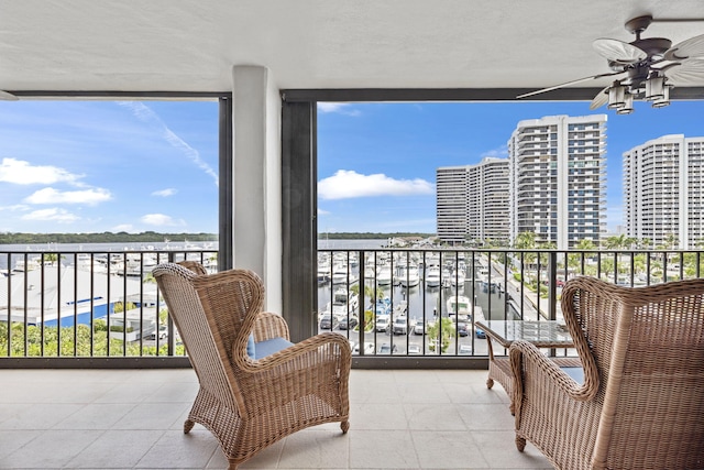 balcony featuring a water view and ceiling fan