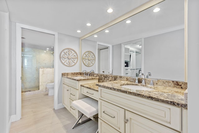 bathroom featuring a shower with door, vanity, toilet, and wood-type flooring