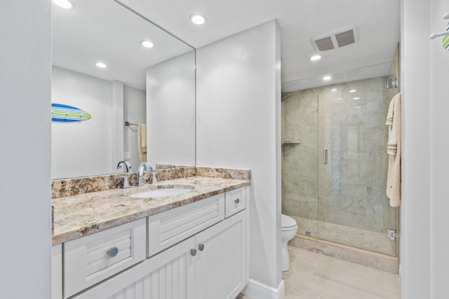 bathroom featuring wood-type flooring, vanity, toilet, and an enclosed shower