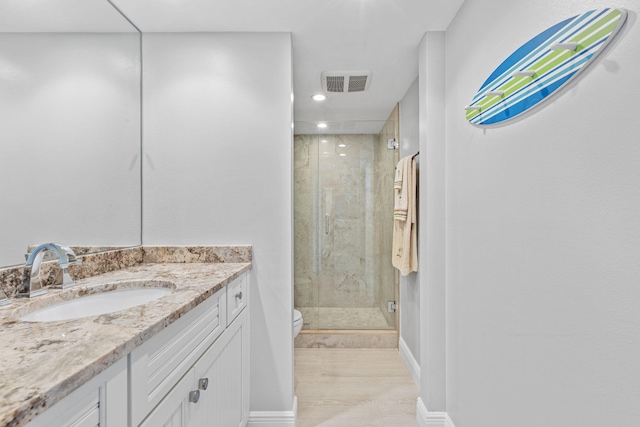 bathroom featuring vanity, tile patterned floors, toilet, and a shower with door