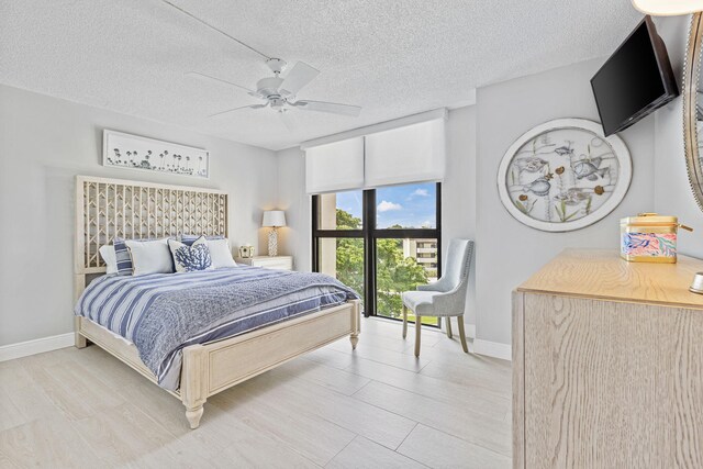 bedroom with a textured ceiling, light hardwood / wood-style floors, and ceiling fan