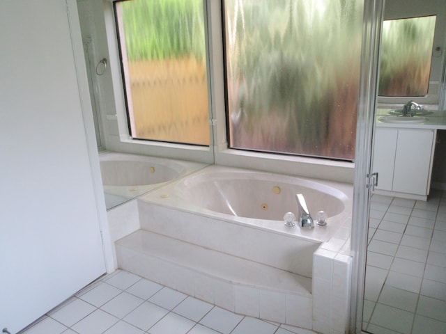 bathroom featuring tiled bath, tile patterned flooring, and vanity