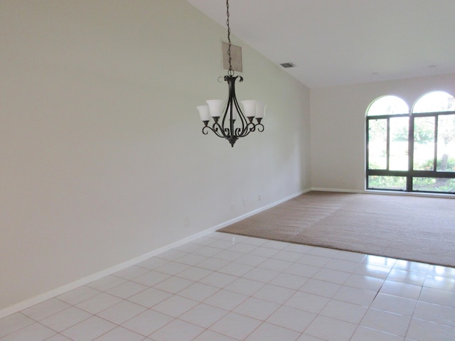 carpeted spare room with an inviting chandelier and vaulted ceiling