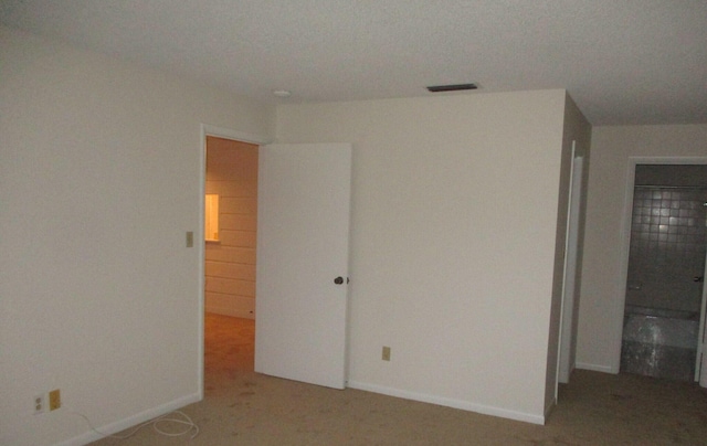 unfurnished bedroom featuring light colored carpet, visible vents, and baseboards