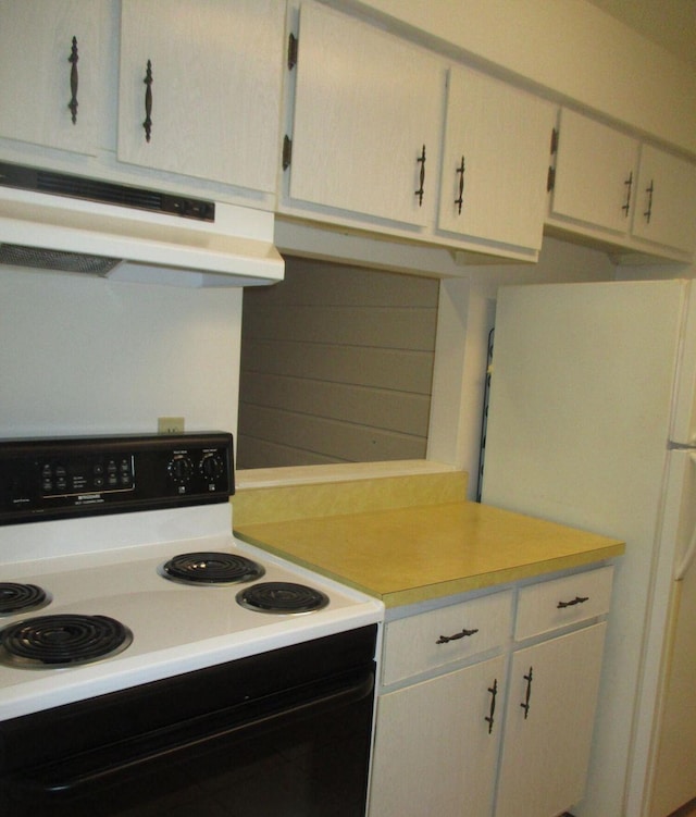 kitchen with under cabinet range hood, range with electric cooktop, white cabinetry, light countertops, and freestanding refrigerator