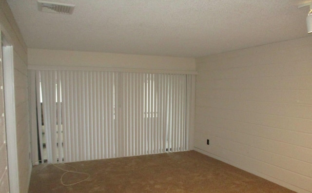 spare room featuring visible vents and carpet flooring