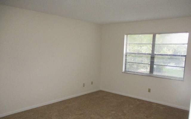 carpeted spare room with baseboards