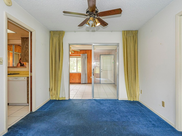 carpeted empty room with a textured ceiling and ceiling fan