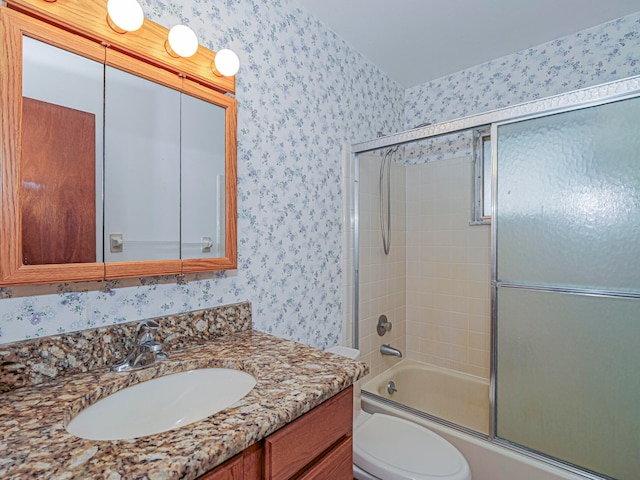 full bathroom with bath / shower combo with glass door, vanity, and toilet