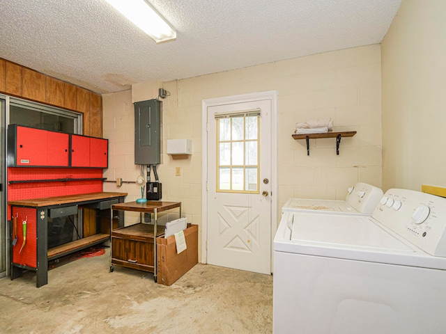 washroom featuring electric panel, washer and dryer, and a textured ceiling