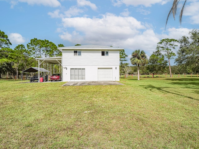 rear view of house featuring a lawn, a garage, and a carport