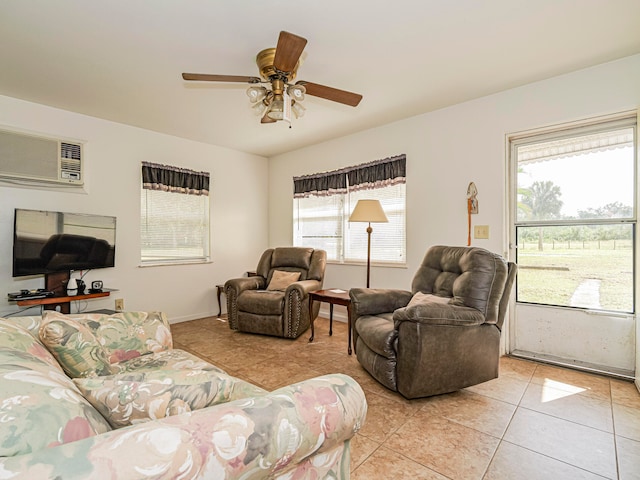 living room featuring a wall unit AC, ceiling fan, and light tile patterned floors