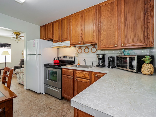 kitchen with sink, appliances with stainless steel finishes, ceiling fan, light tile patterned floors, and backsplash