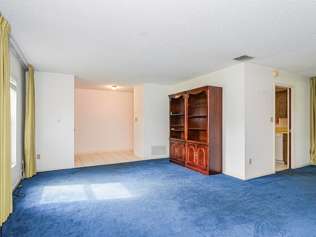 carpeted empty room with a textured ceiling