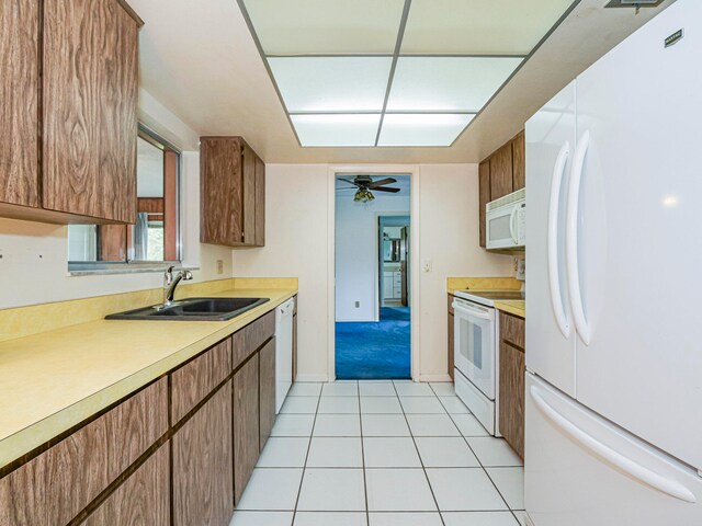 kitchen with light tile patterned floors, white appliances, ceiling fan, and sink