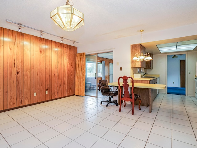 dining area with tile patterned floors, sink, a notable chandelier, and rail lighting