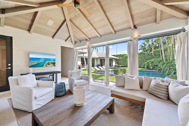 carpeted living room with ceiling fan, beamed ceiling, a healthy amount of sunlight, and high vaulted ceiling