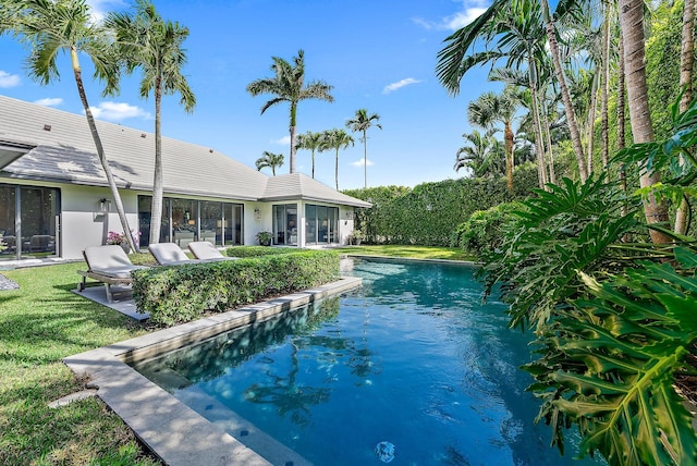 view of pool featuring a lawn