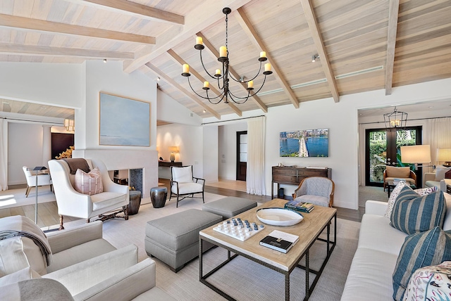 living room featuring beamed ceiling, a notable chandelier, light wood-type flooring, and french doors