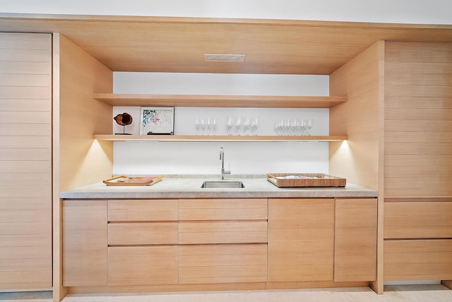 bar with light brown cabinets, wood ceiling, and sink