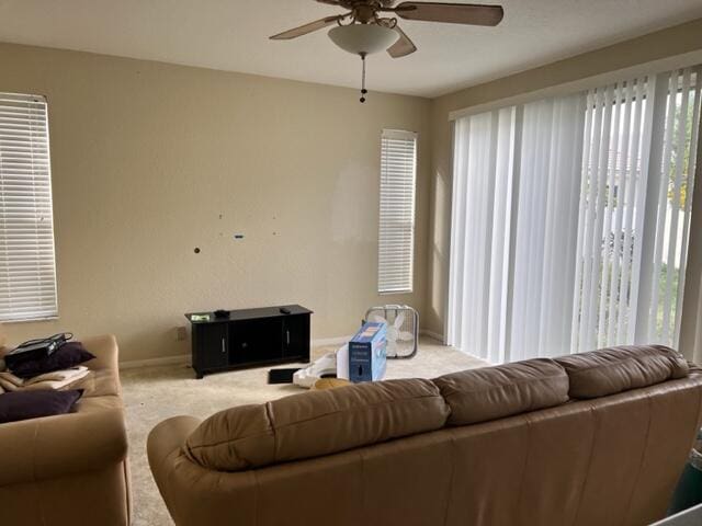 carpeted living room with ceiling fan